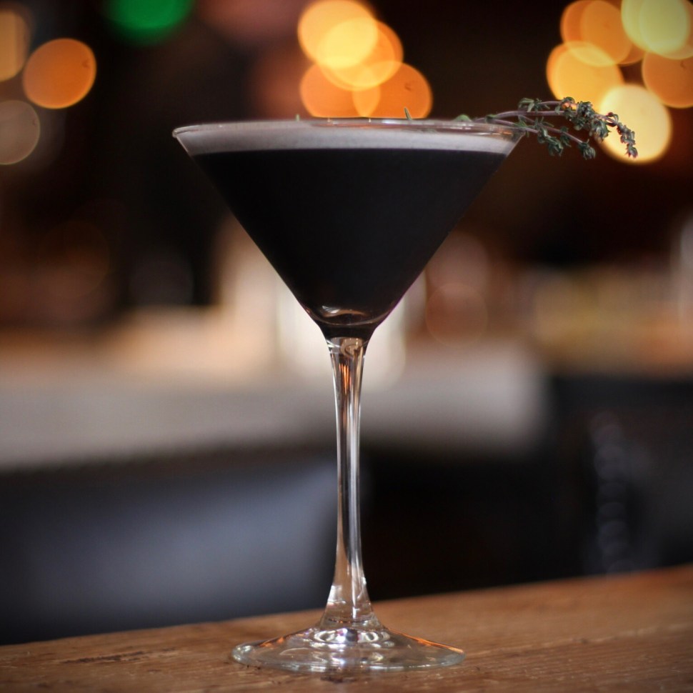 A lavender gin cocktail made with activated charcoal and egg white.
