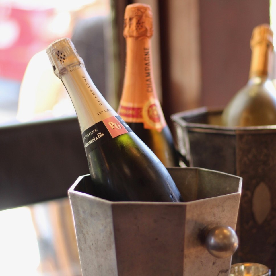 Champagne bottles in buckets on a table.