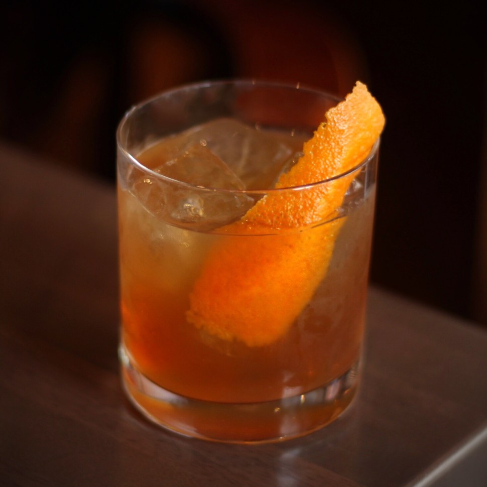 Whiskey cocktail with orange peel.