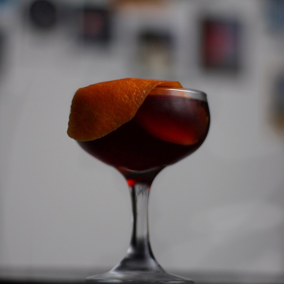 A boozy cocktail with orange peel garnish.